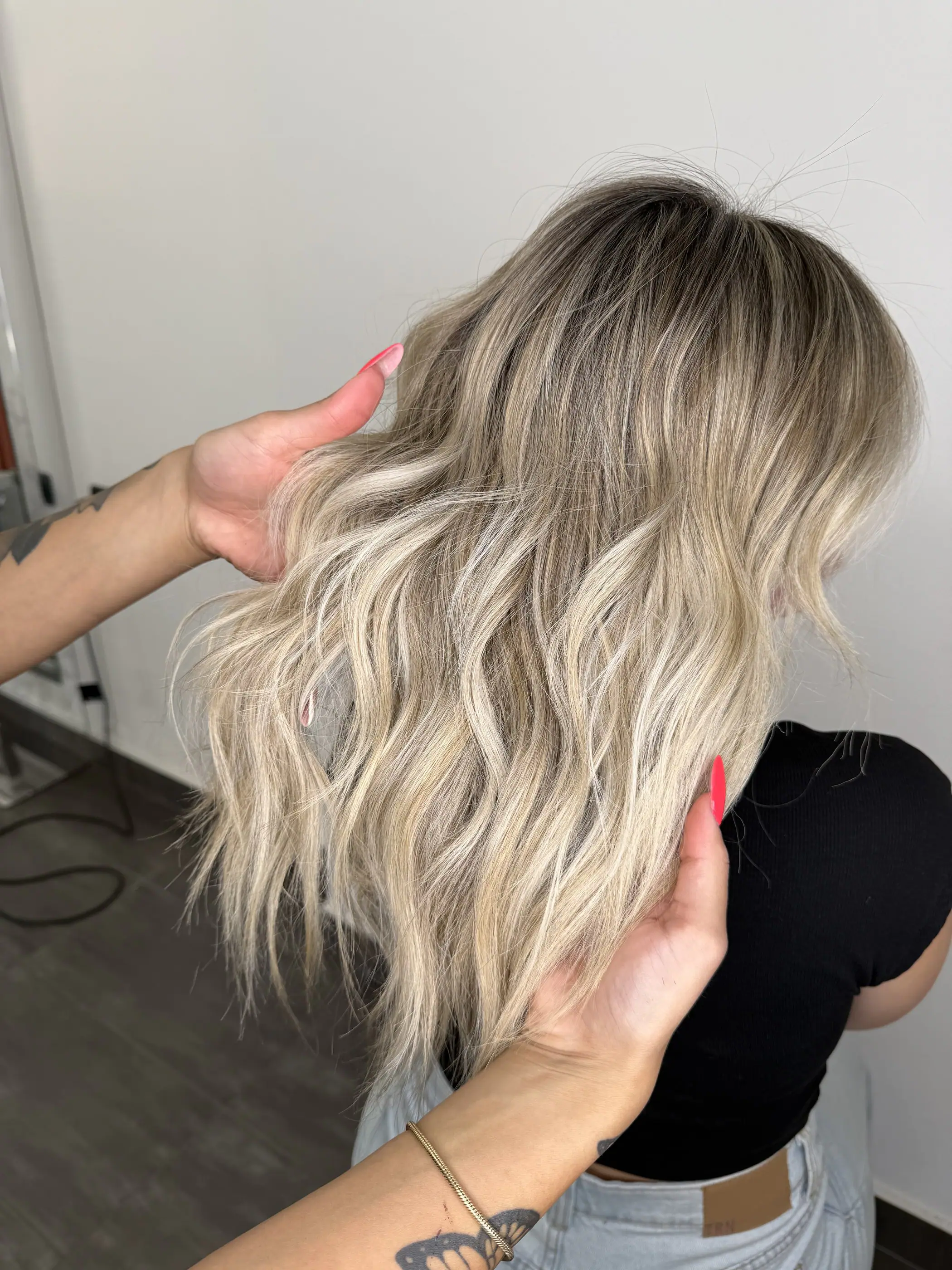 Capelli biondi chiari con sfumature e onde morbide, sistemati a mano